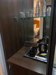 a kitchen with a counter with a stove and glasses at Doolve Hotel Al Khobar in Al Khobar