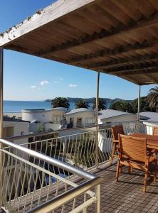 a balcony with a table and chairs and the ocean at Onetangi Beach Apartments in Onetangi