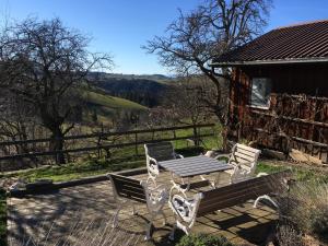 a picnic table and chairs on a patio with a cabin at 3,5 Zimmerferienwohnung Schwalbenäscht Rüeggisberg in Rüeggisberg