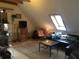 a living room with a black couch and a window at 3,5 Zimmerferienwohnung Schwalbenäscht Rüeggisberg in Rüeggisberg
