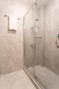 una doccia con porta in vetro in bagno di Sirena's Suites a Istanbul