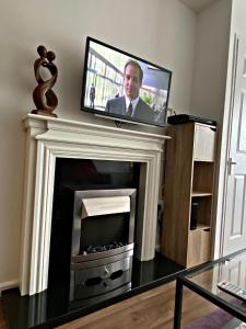 a tv over a fireplace with a tv above it at Serviced Apartment Bristol One-Bedroom Southmead Hospital MOD Airbus in Bristol