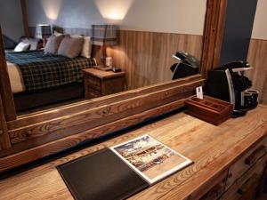 a hotel room with a bed and a mirror at Glacier House Hotel & Resort in Revelstoke