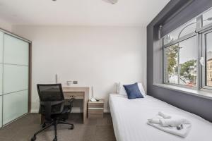 a bedroom with a bed and a desk and a computer at Studios on King in Newcastle