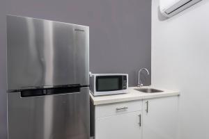 a kitchen with a stainless steel refrigerator and a microwave at Studios on King in Newcastle +14 photos