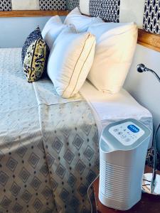 una cama con almohadas y un enfriador de aire junto a ella en Cool Premier Apts. - Airport/SGU, en Blow Hole