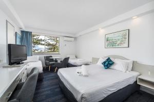 a hotel room with two beds and a television at Alloggio Newcastle Beach in Newcastle