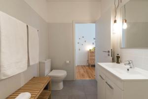 a white bathroom with a toilet and a sink at Light Blue Apartment in Porto
