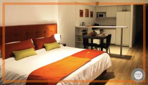 een slaapkamer met een bed en een tafel en een keuken bij Medrano Kind in Buenos Aires