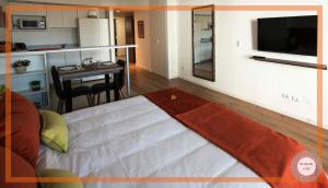 een kamer met een bed en een keuken met een tafel bij Medrano Kind in Buenos Aires