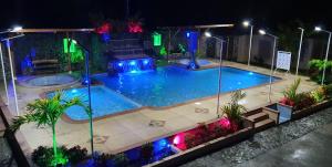 a swimming pool with a fountain at night at Sisakuna Lodge in Mindo