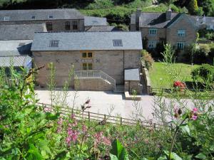 ein großes Steingebäude mit einem Haus im Hintergrund in der Unterkunft Mixit Cottage in Kingsbridge