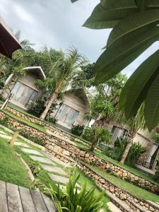 a large garden with trees and a building at Kompyang Cottage in Nusa Penida