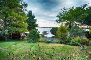 un jardín con vistas al agua en Chambre bord de l'eau oka en Oka