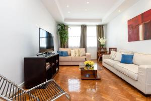 a living room with a couch and a tv at Espaçoso 3Qtos no Leblon com Garagem | BM 647/405 in Rio de Janeiro