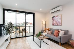 uma sala de estar com um sofá e uma mesa em The East End Apartments by Urban Rest em Adelaide