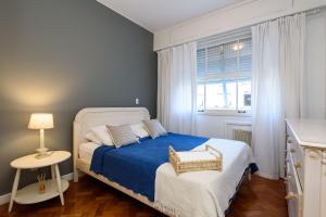a bedroom with a bed with blue sheets and a window at Espaçoso 3Qtos no Leblon com Garagem | BM 647/405 in Rio de Janeiro