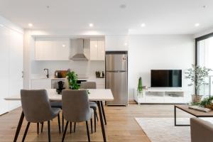 uma cozinha e sala de estar com mesa e cadeiras em The East End Apartments by Urban Rest em Adelaide