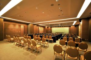 uma sala de conferências com filas de cadeiras e um ecrã em Academy Hotel em Tainan