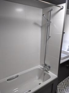 a white bathroom with a tub and a sink at Central Hawick spacious stylish flat with log burner in Hawick