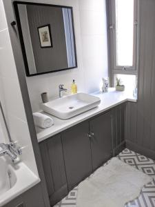 a bathroom with a sink and a mirror at Central Hawick spacious stylish flat with log burner in Hawick