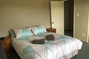 a bedroom with a bed with two stuffed animals on it at Irishman Retreat in Twizel
