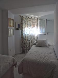 Tempat tidur dalam kamar di Duplex, terraza, 10 min coche centro Sevilla