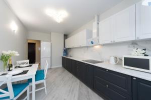 a kitchen with white cabinets and a table and a microwave at Красивая 1 комнатная квартира с балконом на Теремках 252 in Kyiv