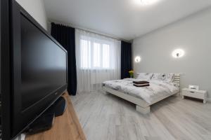a bedroom with a flat screen tv and a bed at Красивая 1 комнатная квартира с балконом на Теремках 252 in Kyiv