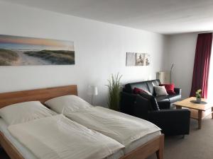 a bedroom with a bed and a couch and a chair at Steiner Strandappartements Appartement 206 Süd- Landseite in Stein