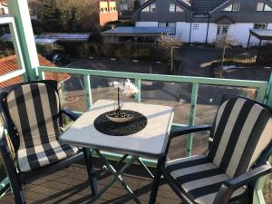 a table and two chairs on a balcony with a candle at Steiner Strandappartements Appartement 206 Süd- Landseite in Stein