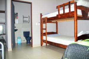 a bedroom with two bunk beds and a toilet at Apartamentos Mansión Tropical in Quepos