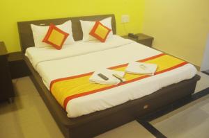 a bed in a hotel room with two towels on it at Hotel Sunrise N Resorts in Nagpur