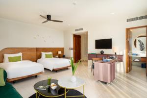 a hotel room with two beds and a tv at The Aviary Hotel in Siem Reap
