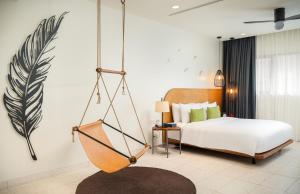 a bedroom with a bed and a swing at The Aviary Hotel in Siem Reap