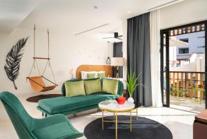 a living room with a green couch and a table at The Aviary Hotel in Siem Reap