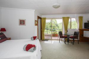 una camera d'albergo con letto, tavolo e sedie di A view of Mount Warning a Uki