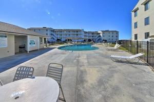 um pátio com cadeiras e uma piscina num edifício em Emerald Isle Resort-Style Condo Walk to Beaches! em Emerald Isle