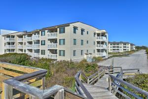 a boardwalk leading to an apartment complex with condos at Emerald Isle Resort-Style Condo Walk to Beaches! in Emerald Isle