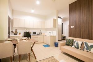 cocina y sala de estar con sofá y mesa en Urban Cottage@Midhill Genting Highlands (Free Wi-Fi) en Bentong