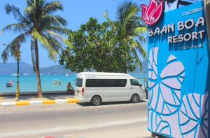 uma carrinha branca estacionada ao lado de uma praia em Baan Boa Resort em Praia de Patong