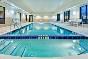 una piscina en un hotel con sillas y mesas en Holiday Inn Express & Suites White Haven - Poconos, an IHG hotel en White Haven