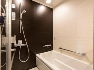 a bathroom with a bath tub and a shower at Solaria Nishitetsu Hotel Kagoshima in Kagoshima
