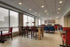 un comedor con mesas, sillas y ventanas en Holiday Inn Express Voorhees/ Mt. Laurel, an IHG Hotel, en Voorhees