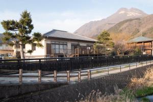 una casa a orillas de un río con una montaña en Bettei Gensen-Private Vacation Villa Bettei Gensen, en Yufu