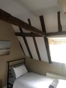 a room with two beds and a ceiling with wooden beams at 18th Century Character apartment. in Ipswich
