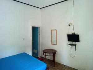 a bedroom with a blue bed and a stool and a television at Latansa inn in Karimunjawa