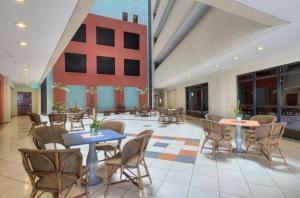 a lobby with tables and chairs and a building at Flat Iate in Fortaleza