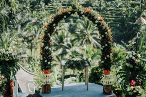 um arco de casamento com flores sobre uma mesa em Pondok Sebatu Villa em Tegalalang