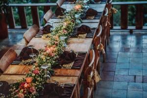 uma longa mesa de madeira com flores em Pondok Sebatu Villa em Tegalalang